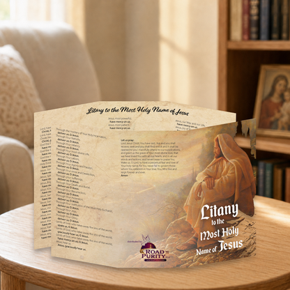 Litany to the Most Holy Name of Jesus prayer card displayed in a warm Catholic reading area